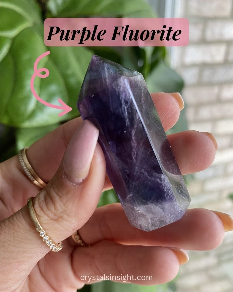 Purple fluorite tower in hand of a female 