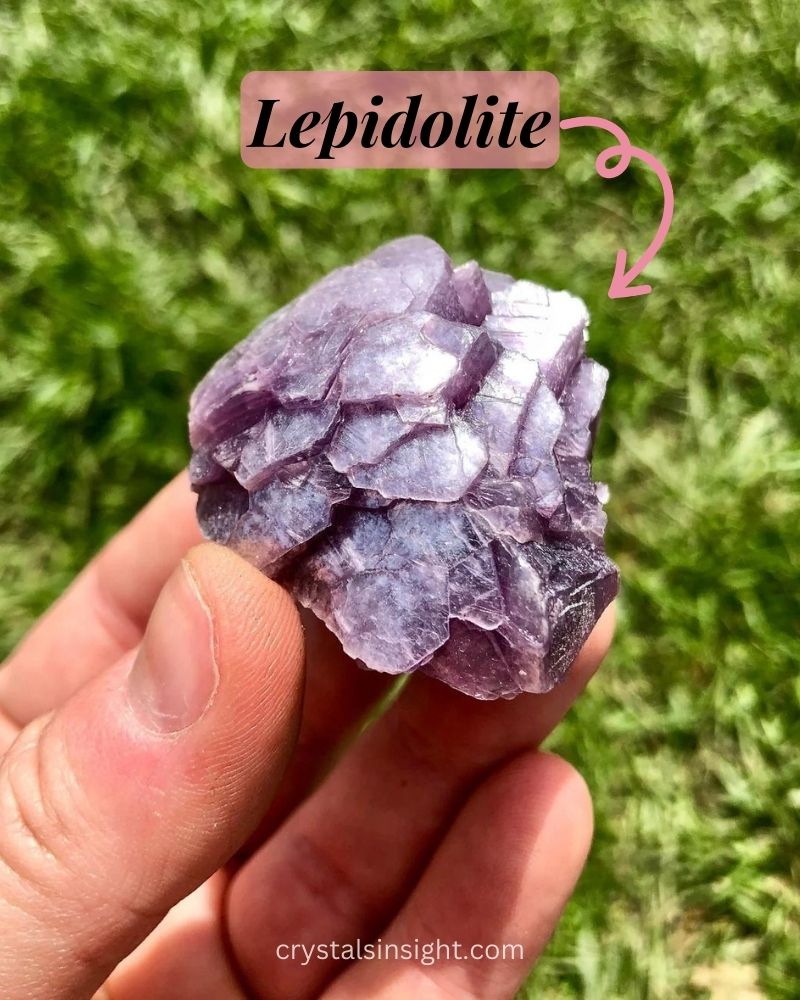 Lepidolite stone a stunning lilac or lavender mineral, reminiscent of a dreamy sunset sky in a hand of man.